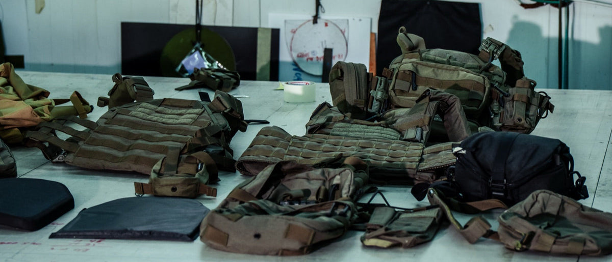 Plate carriers and armor plates laid out on a workshop table
