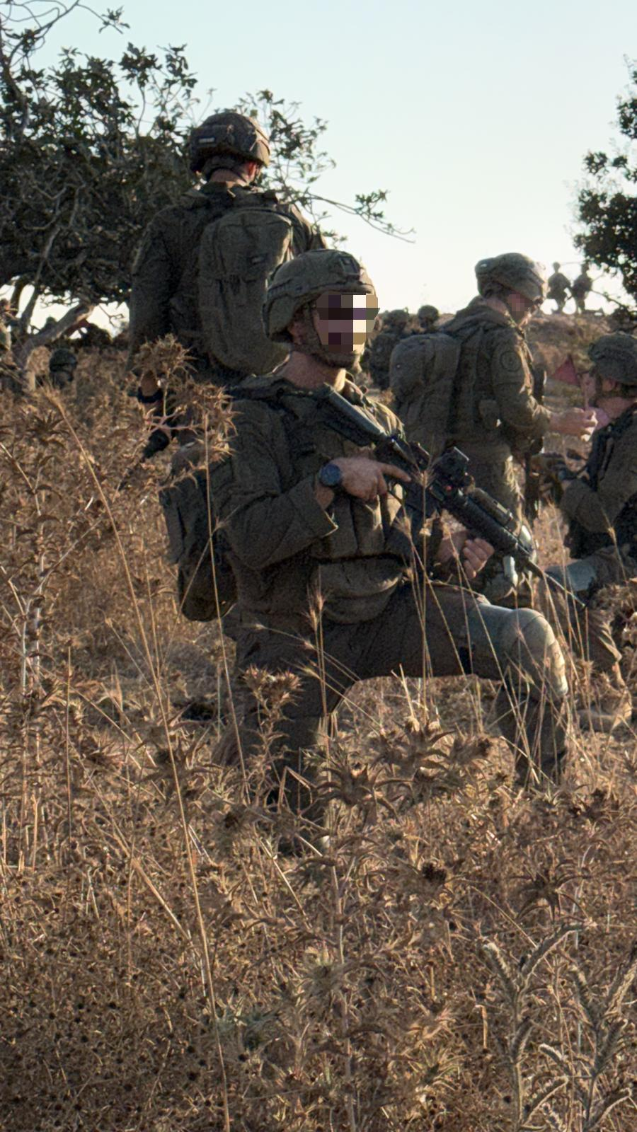 לוחמים עם ציוד בשטח, עם טשטוש פיקסלים לשמירה על פרטיות